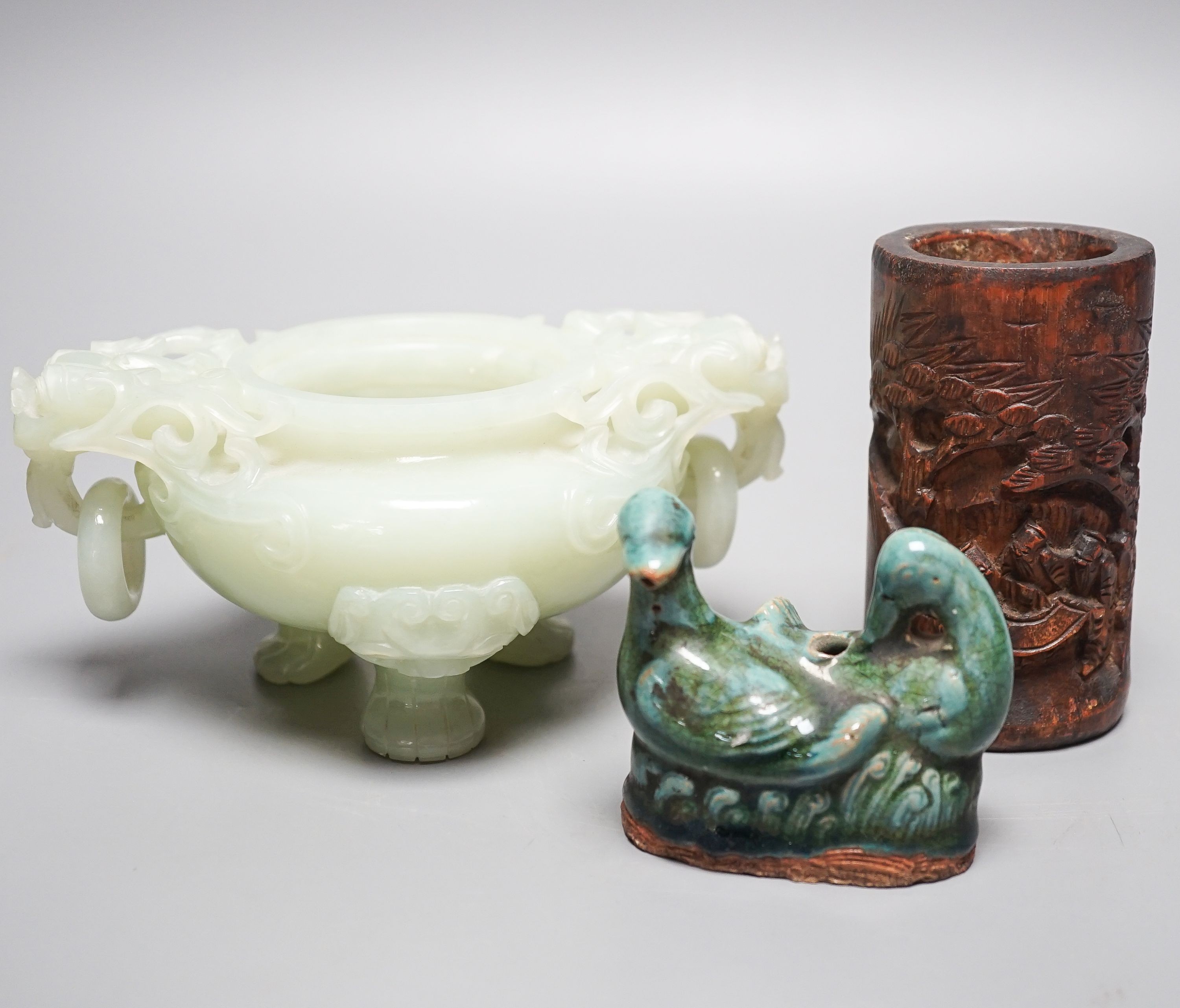 A Chinese bowenite jade tripod censer, 17cm wide, a Chinese green glazed ‘duck’ water dropper and a small bamboo brush part, 19th/20th century (3)